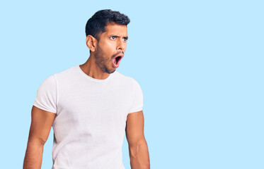 Young latin man wearing casual clothes angry and mad screaming frustrated and furious, shouting with anger. rage and aggressive concept.