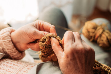 Close-up of elderly woman hands knitting. Wintertime