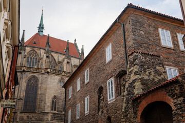 Fototapeta na wymiar Medieval stone St. Bartholomew´s Church, Gothic Cathedral at the end of narrow street in autumn day, arched windows, chimeras and gargoyles, Kolin, Central Bohemia, Czech republic