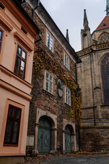 Fototapeta premium Regional Museum with ivy-covered wall, Dvorak´s Museum of Prehistory or formerly parish school near Gothic Cathedral, Medieval stone St. Bartholomew´s Church, Kolin, Czech republic