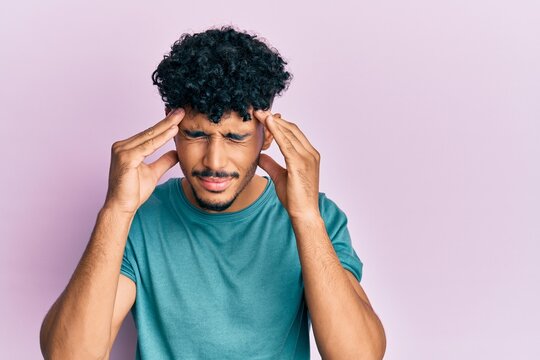 Young arab handsome man wearing casual clothes with hand on head for pain in head because stress. suffering migraine.