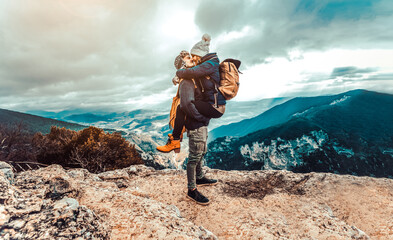 Couple in love kissing on the top of a hill - Romantic hikers climbing mountains