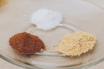 Grated cinnamon, graded ginger and sugar powder close-up on glass plate. Macro shot. Selective focus.