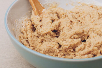 Process of kneading gingerbread dough using wooden scapula. Close-up shot.