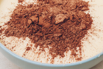 Dough with bunch of cacao on top, close-up. Preparing process to baking. Macro shot.