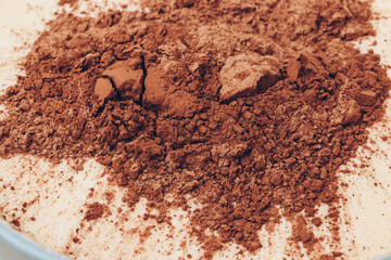 Dough with bunch of cacao on top, close-up. Preparing process to baking. Macro shot.