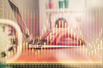Double exposure of woman hands typing on computer and forex chart hologram drawing. Stock market...