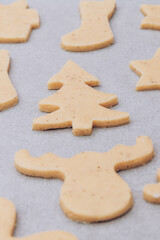 Fototapeta na wymiar Raw gingerbread cookies on the white baking sheet.