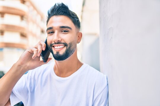 Young arab man with serious expression talking on the smartphone at the city.