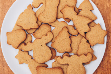 Tasty Christmas gingerbread cookies on the white plate.