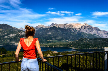 Beautiful woman from behind contemplating the immensity of the landscape of mountains, pine trees...