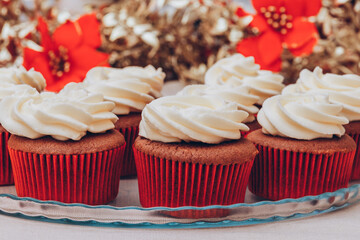 Delicious chocolate cupcakes with swirled frosting cream on top. Cupcakes on a glass tray with colorful holiday background.