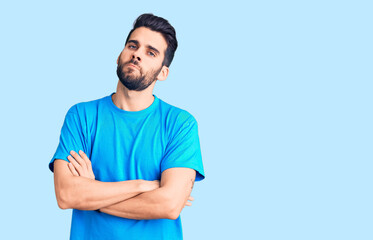Fototapeta premium Young handsome man with beard wearing casual t-shirt skeptic and nervous, disapproving expression on face with crossed arms. negative person.