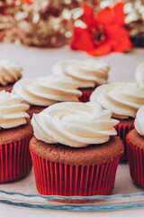 Delicious chocolate cupcakes with swirled frosting cream on top. Cupcakes on a glass tray with colorful holiday background.