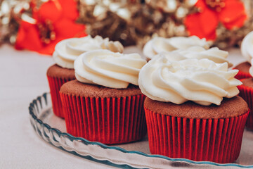 Delicious chocolate cupcakes with swirled frosting cream on top. Cupcakes on a glass tray with colorful holiday background.