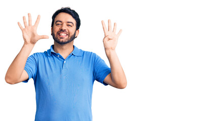 Young hispanic man wearing casual clothes showing and pointing up with fingers number nine while...