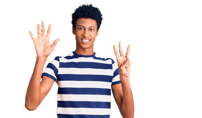 Naklejka premium Young african american man wearing casual clothes showing and pointing up with fingers number eight while smiling confident and happy.
