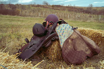 Saddle and horse riding equipment on the field in autumn or winter day