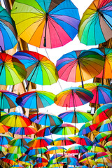 A set of colorful umbrellas or parasols covers a small alley of Bucharest.