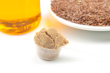 ground flaxseed and oil on white background. vitamins and healthy food