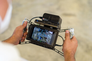 manos de hombre sujetando monitor de referencia para cámaras de video y cine digital