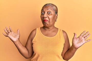 Senior african american woman wearing casual style with sleeveless shirt clueless and confused with...