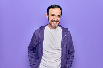 Fototapeta premium Middle age handsome sporty man wearing casual purple sweatshirt over isolated background with a happy and cool smile on face. Lucky person.