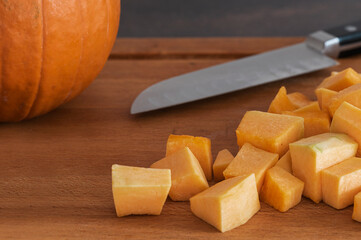 Pumpkin and knife on wooden board
