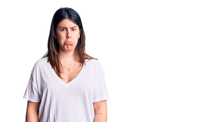 Young beautiful brunette woman wearing casual t-shirt depressed and worry for distress, crying angry and afraid. sad expression.