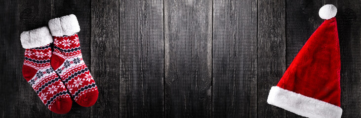 Santa Claus hat on wooden rustic background. Top view. Long banner.