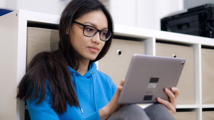 Young woman works with a tablet computer - home shooting