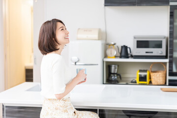 部屋で飲み物を飲む女性