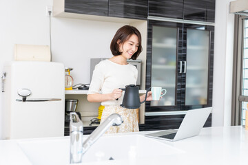 キッチンでパソコンを見る女性　お茶