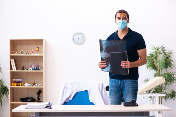 Young man waiting for doctor during pandemic in hospital