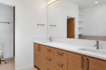 Fototapeta na wymiar Bathroom in luxury home with double vanity, mirror, sink, and tile floor
