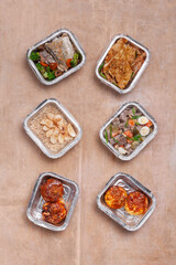 Fototapeta na wymiar take away lunch boxes with fresh meal in foil container or healthy food delivery