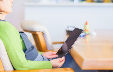 Japanese senior woman looking at tablet device