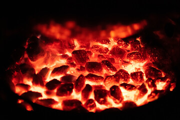 Bed of red hot flaming charcoal briquettes in a grill smoker