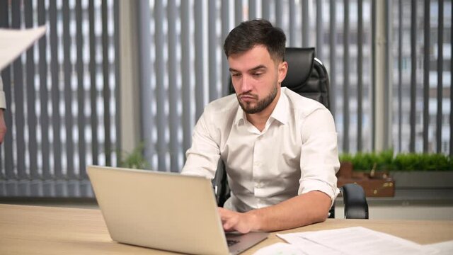 Colleagues and executives overwhelmed the young male head of the office with work. Too much work for one person, overload