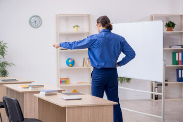 Young male teacher in front of white board