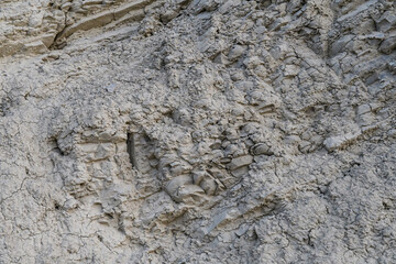 Steep wall of clay rock, with a bunch of cracks, closeup black and white color
