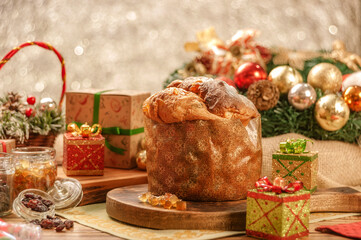 Fototapeta na wymiar Panettone, raisins and candied fruit cubes on wooden cutting board with christmas ornaments