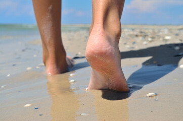 Human legs close up on the background of the sea beach