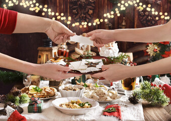 family sharing Christmas Eve wafer at the festive table