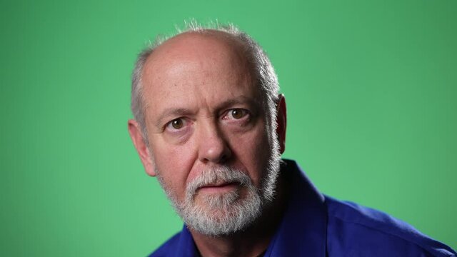 Slow motion closeup of man shocked, saying WOW. Handsome guy with bald gray hair surprised to camera on green screen background.