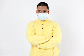 Asian man in a protective mask looking at camera on white background