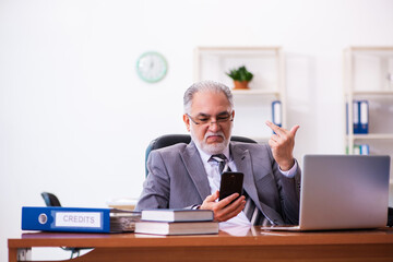 Old male businessman employee working in the office