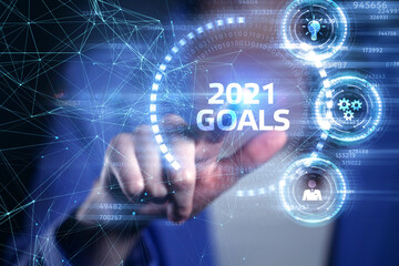 Business, Technology, Internet and network concept. Young businessman working on a virtual screen of the future and sees the inscription: 2021 goals