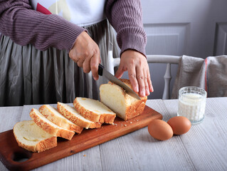 Female Chef Hold Knife to Cut or Slicing White Japanese Brioche Hokkaido Bread with Cheese Topping