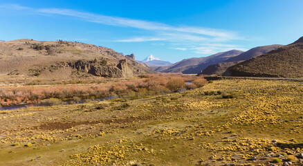 Zigzagging river crossing the Patagonian steppe in Neuquen, Argentina, near the Andes mountain...